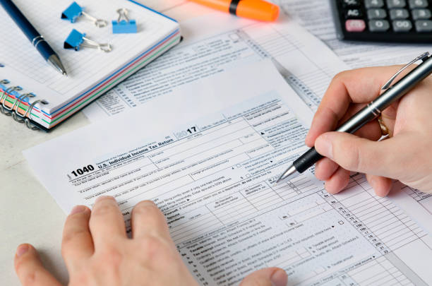 istock Man filling US tax form. 911758596