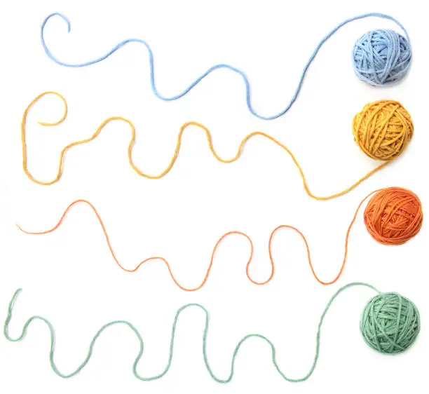 Set of four color (orange, yellow, green, blue) thread balls.