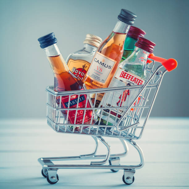 Minsk, Belarus - January 16, 2018: Illustrative editorial photo of mini shopping cart full of small alcohol bottles - Jameson whiskey, Camus and Martell cognacs, Havana club rum, Beefeater gin. Minsk, Belarus. Illustrative editorial photo. Minsk, Belarus - January 16, 2018: Illustrative editorial photo of mini shopping cart full of small alcohol bottles - Jameson whiskey, Camus and Martell cognacs, Havana club rum, Beefeater gin. Minsk, Belarus. njemp tribe stock pictures, royalty-free photos & images
