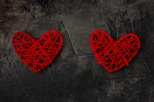 istock Two hearts with a plus sign against a dark background. Theme for St. Valentine's Day 911787912