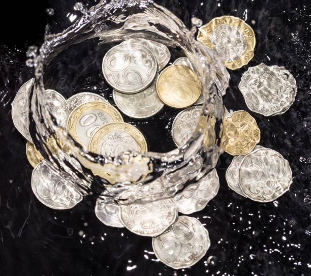 istock coins in water splashes on a black background 911794134
