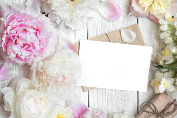 istock Creative layout made of peony, rose and jasmine flowers with blank greeting card and gift box 911802468