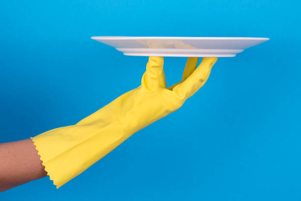 istock Hands in yellow protective gloves washing a plate 911802620