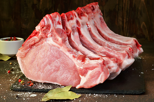 Cerdo con las costillas. Solomillo. Entrecot. Carne fresca y cruda. Alimentos orgánicos. Carne con especias: pimienta, sal, hoja de laurel. photo