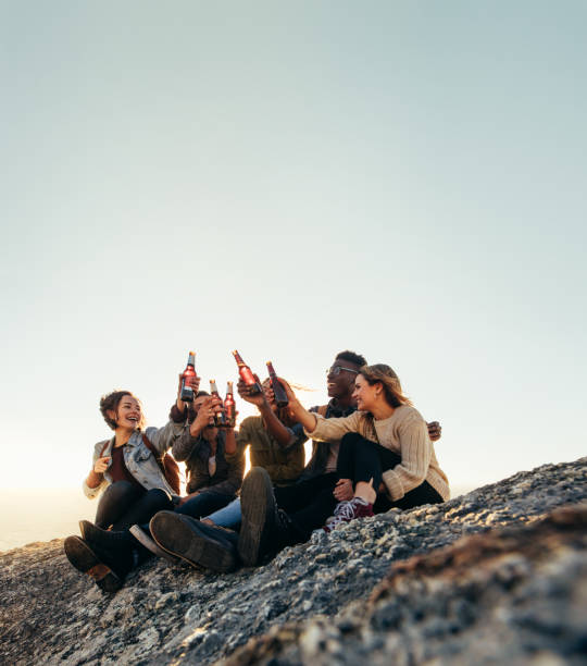 amici in cima a una montagna che festano con le birre - friendship drinking beer group of people foto e immagini stock