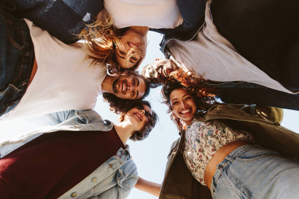 istock Smiling young friends forming a huddle 911812446