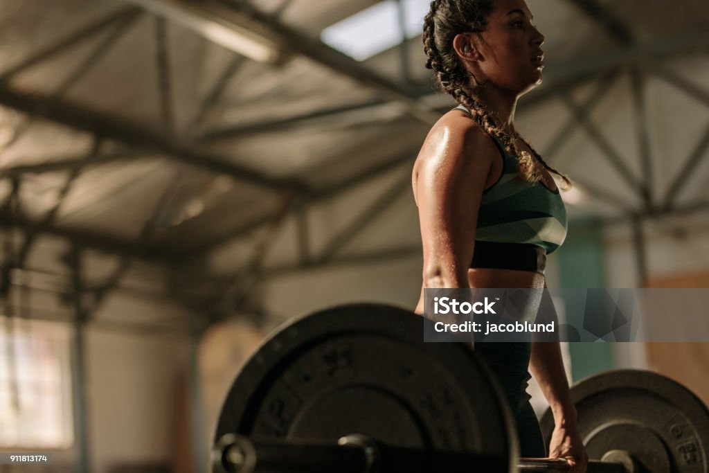 Muscular woman doing heavy weight exercises Muscular woman in gym doing heavy weight exercises. Young woman doing weight lifting at health club. Women Stock Photo