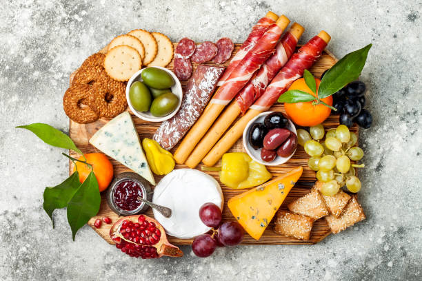 istock Appetizers table with antipasti snacks. Cheese and meat variety board over grey concrete background. Top view, flat lay 911813614