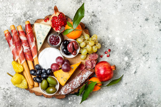 istock Appetizers table with antipasti snacks. Cheese and meat variety board over grey concrete background. Top view, flat lay 911813752