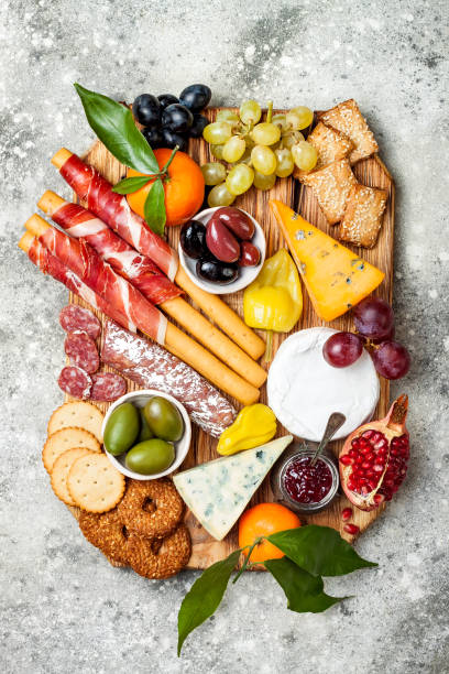 istock Appetizers table with antipasti snacks. Cheese and meat variety board over grey concrete background. Top view, flat lay 911813806