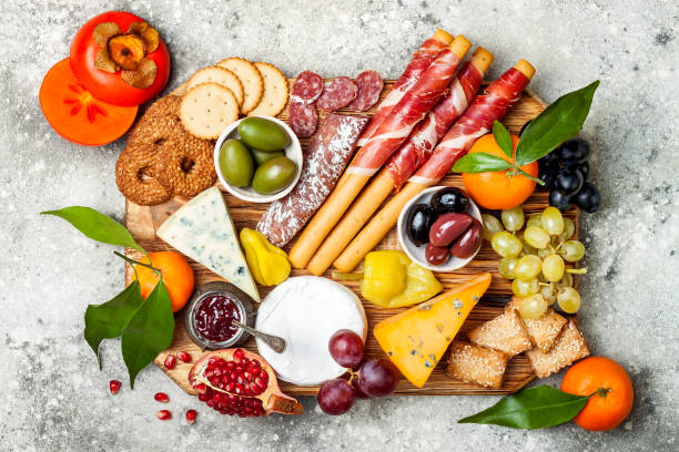 istock Appetizers table with antipasti snacks. Cheese and meat variety board over grey concrete background. Top view, flat lay 911813882