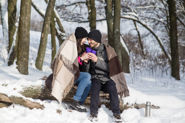 istock Lovely couple sitting on log under plaid 911814210