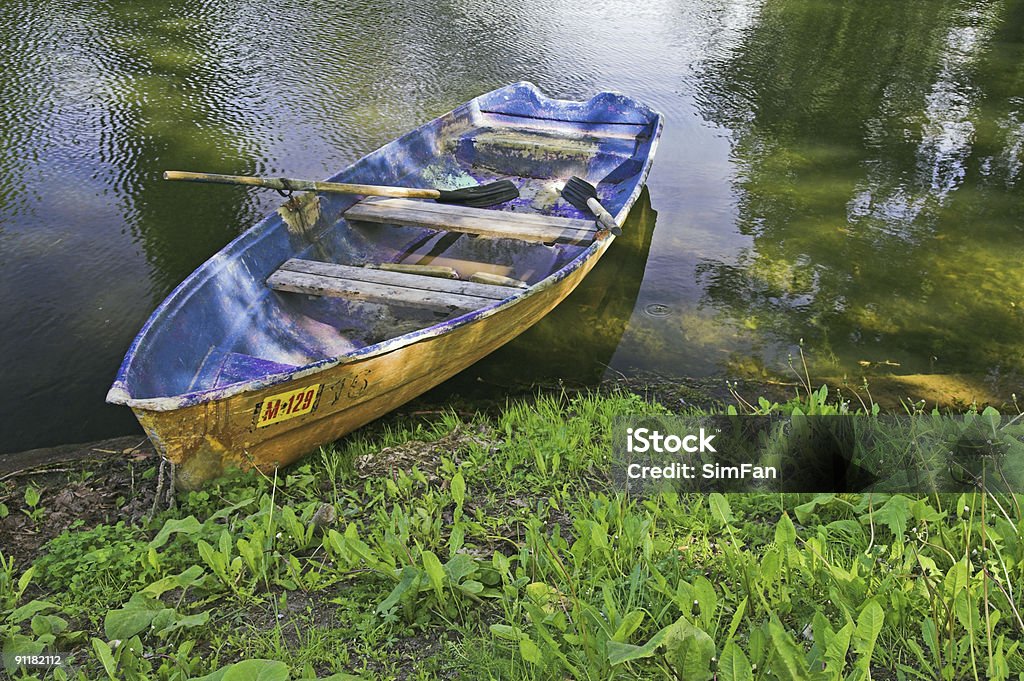 Boat at pond bank Boat at pond bank in summer park Pond Stock Photo