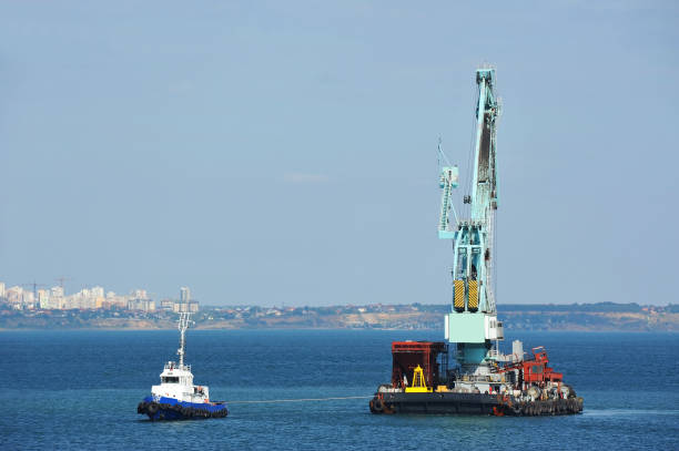 istock Tugboat assisting floating cargo crane 911823916