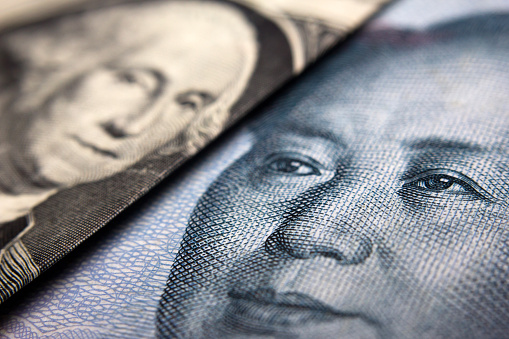 Close-up of a Chinese yuan and an American banknote