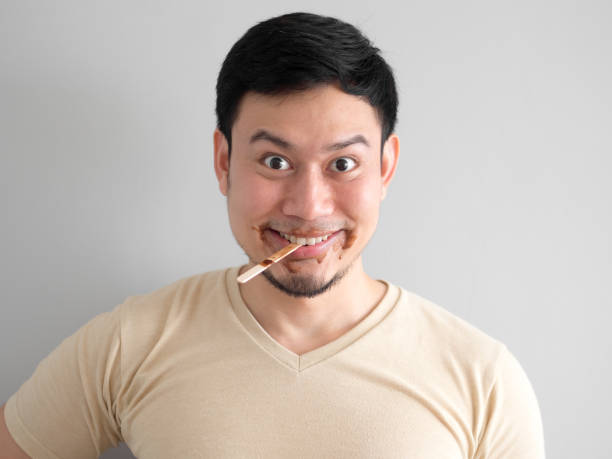 istock Funny face man eat chocolate vanilla ice pop. 911830760