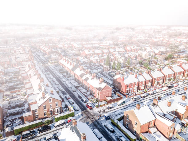 Aerial view of a snow blizzard covering a traditional housing suburbs in England. stock photo