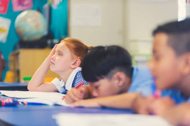 istock School children bored and tired in class. 911839526
