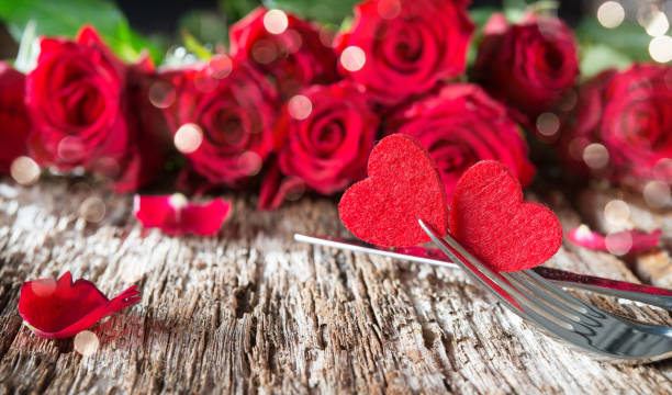 istock Hearts on forks in front of red roses 911840232