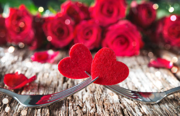 istock Hearts on forks in front of red roses 911840260