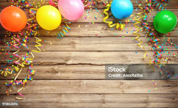 Colorful Carnival Or Party Frame Of Balloons Streamers And Confetti On Rustic Wooden Board Stock Photo - Download Image Now