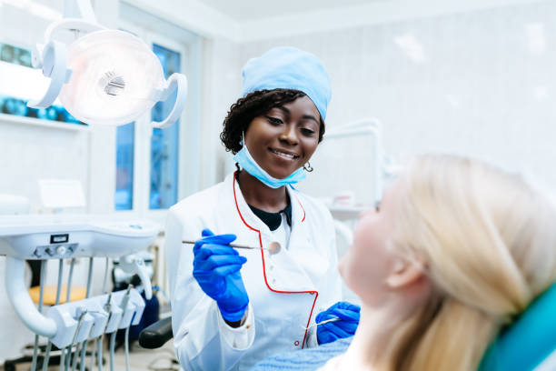 afro-américain femelle dentiste traitant patient à la clinique. concept de clinique dentaire - dental assistent photos et images de collection