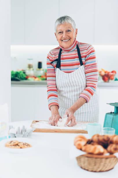 istock Senior woman preparing bread 911843108