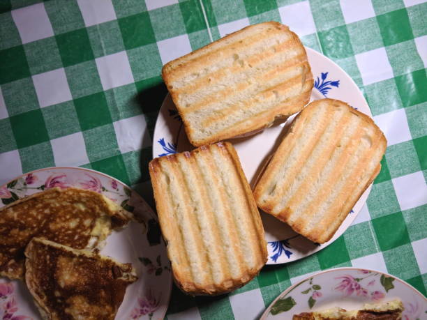 istock Sandwiches and scrambled eggs on the kitchen table, home cooking, breakfast on a day off, American food, sandwich on the grill 911849490