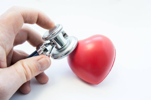 doctor holding estetoscopio en mano, analiza la forma del corazón para detectar presencia de enfermedades del sistema cardiovascular. foto para el uso en cardiología, cirugía cardiaca, diagnóstico y tratamiento de enfermedades del corazón - fibrillation fotografías e imágenes de stock