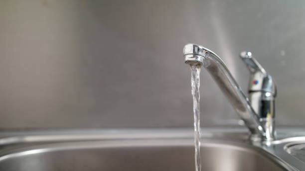 acqua che scorre da un rubinetto - rubinetto foto e immagini stock