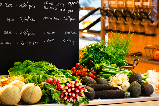 Supermarket , fruit and vegetable zone. Blackboard in supermarket prices and blurred background