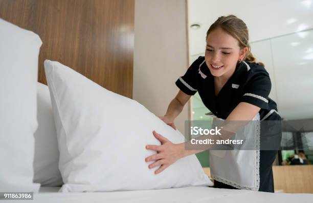 Housekeeper Making The Bed At A Hotel Looking Happy Stock Photo - Download Image Now
