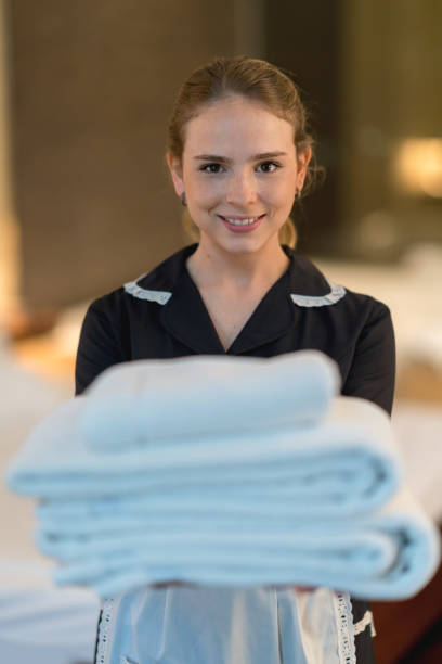 istock Housekeeper smiling at the camera and handing towels 911864078