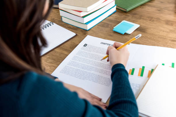 istock Female college student reading information on paper, doing homework 911864876
