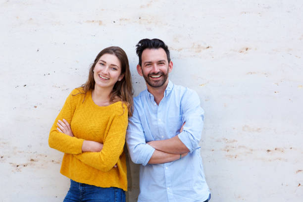 istock Happy couple standing with arms crossed laughing 911865020