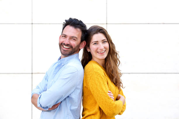 istock Playful couple standing back to back with arms crossed 911865034