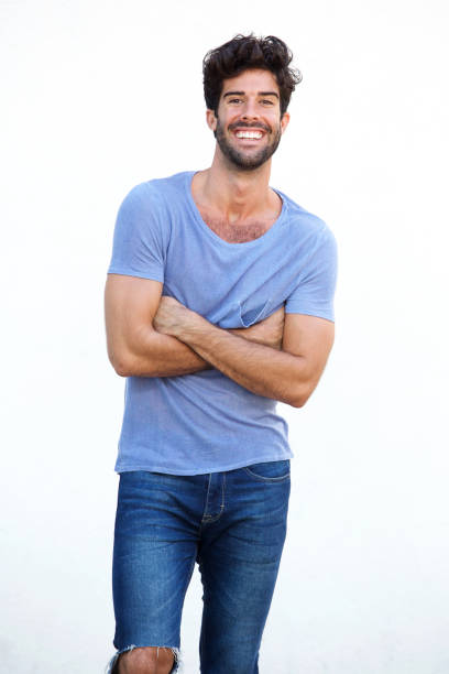 istock Smiling man standing with arms crossed isolated on white 911865060