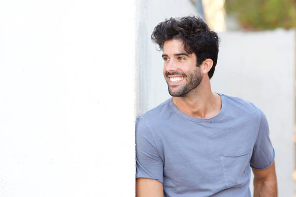 istock Confident handsome man standing outside by wall 911865142