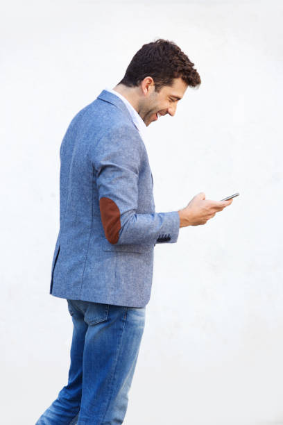 istock Side of happy young man using mobile phone on white background 911867338