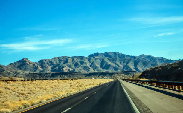 Scenic road travel with mountains and trees in background Desert scenery driving with view of mountains and road signs marie puddu stock pictures, royalty-free photos & images