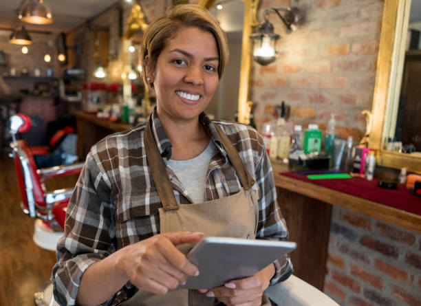 istock Hairstylist using a tablet computer at a barber shop 911870572