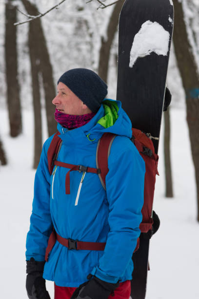 istock Happy snowboarder with backpack stands in the forest 911879230