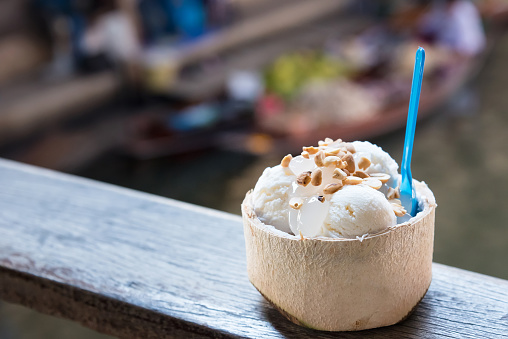 Coconut ice cream. Sweet coconut ice cream in the fresh coconut and plastic spoon. coconut ice cream is very popular dessert in market.Thailand