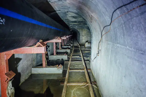Construction of sewer pipeline from plastic pipes in sewer tunnel with narrow-gauge railway.