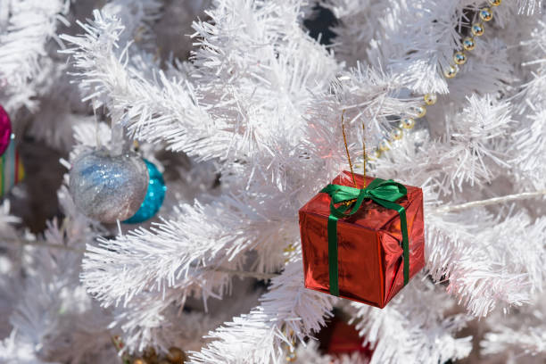 istock White Christmas tree with colorful ornaments outside. 911885730