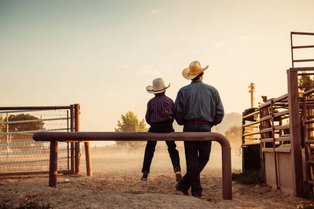 father and son at rodeo arena - agriculture teamwork farmer people imagens e fotografias de stock
