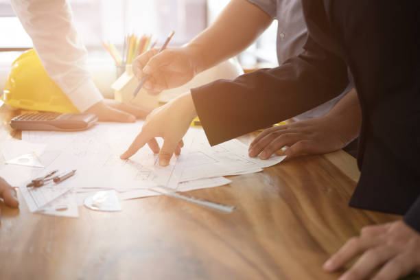istock Architect working on real estate project with partner at workplace. engineer discussing with colleague on house blueprint at office. Business, people, construction and building concept 911892854