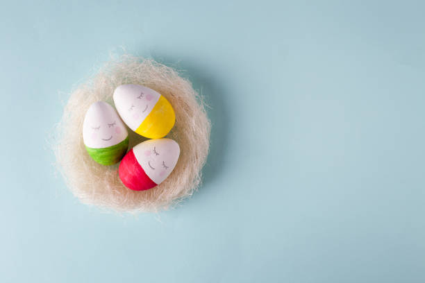 istock Funny Easter eggs in a nest of sisal, smiling faces 911904004