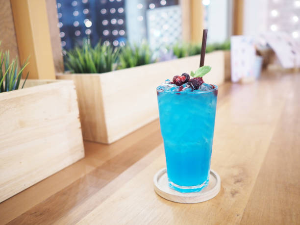 glass of blue cocktail with berries fruit