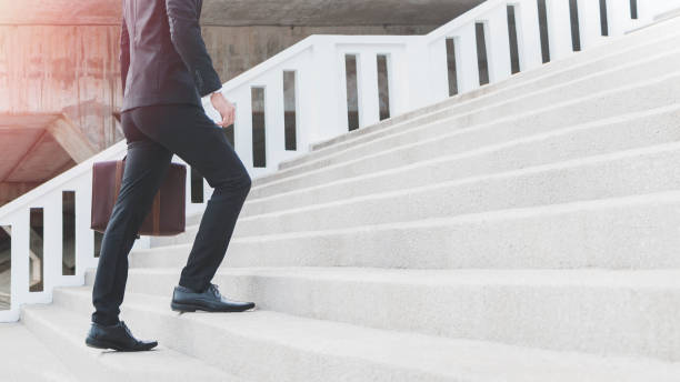 jovem inteligente empresário segurando a mala e a subir as escadas. conceito de etapa de negócios de sucesso. - black ladder white staircase - fotografias e filmes do acervo